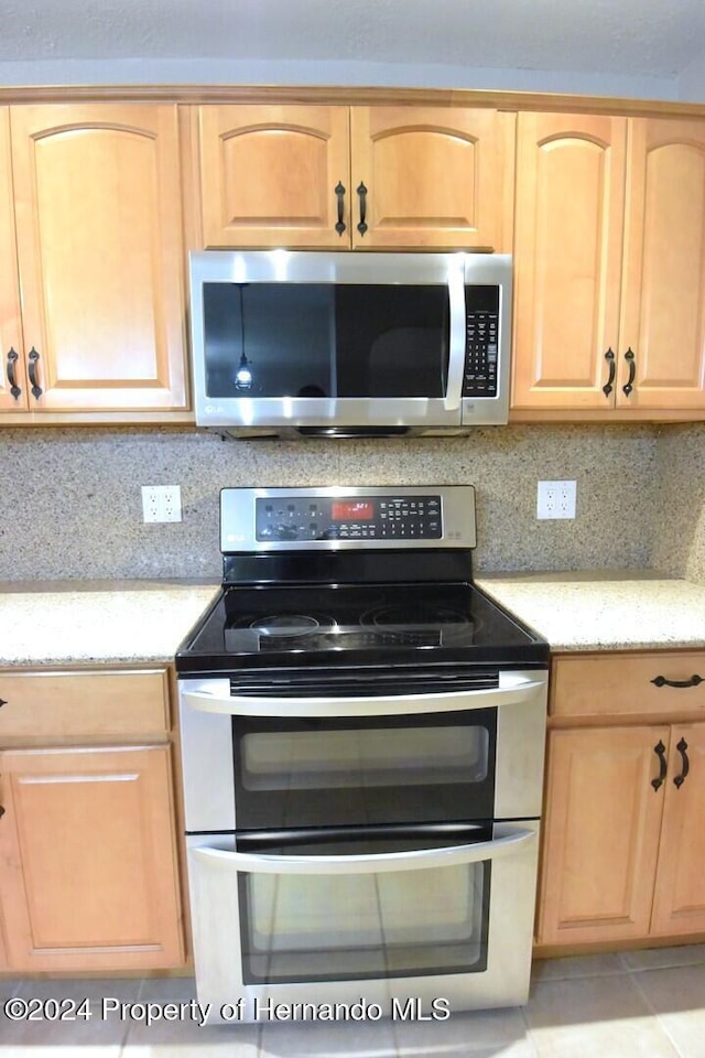 kitchen with light brown cabinets, backsplash, stainless steel appliances, and light tile patterned floors