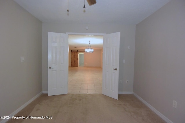 spare room featuring light colored carpet and ceiling fan