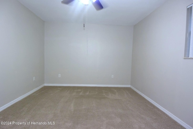 empty room with light colored carpet and ceiling fan