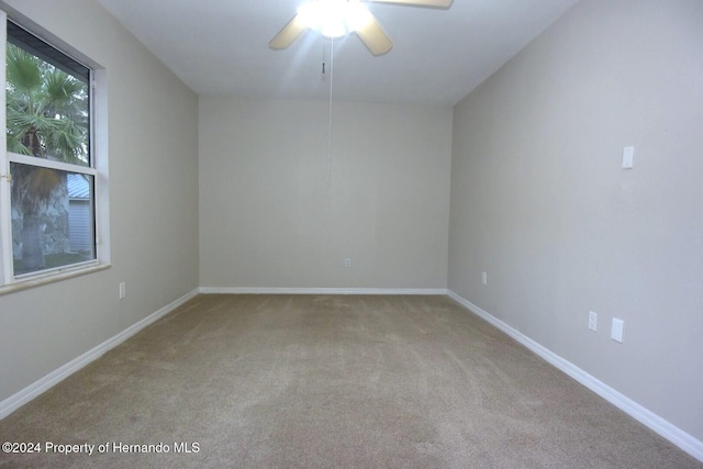 carpeted spare room with ceiling fan