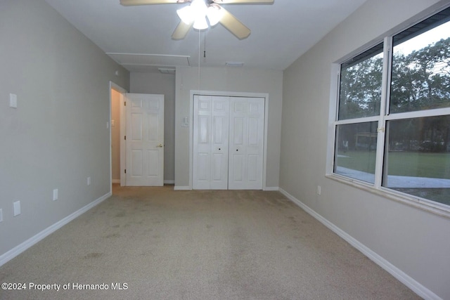 unfurnished bedroom featuring carpet, a closet, and ceiling fan