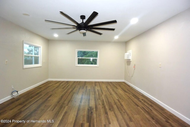 spare room featuring ceiling fan, a healthy amount of sunlight, and dark hardwood / wood-style floors