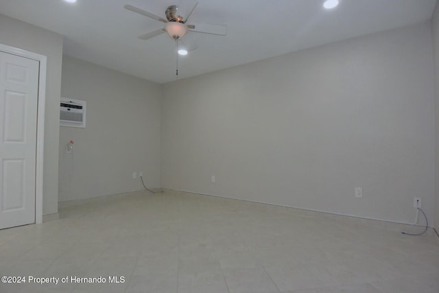 spare room with ceiling fan and a wall mounted AC