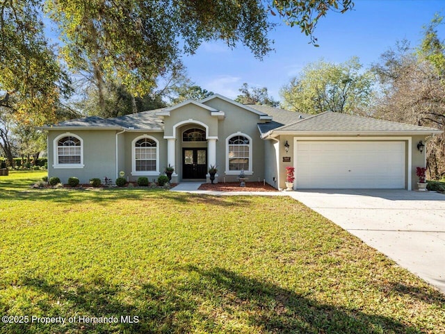 ranch-style home featuring french doors, stucco siding, a front yard, a garage, and driveway