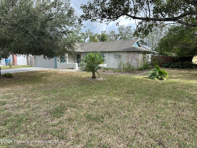 single story home featuring a garage and a front lawn