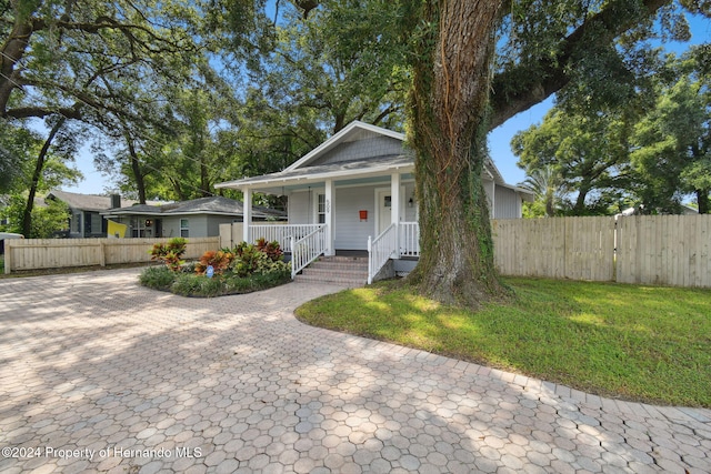 bungalow with a porch and a front lawn