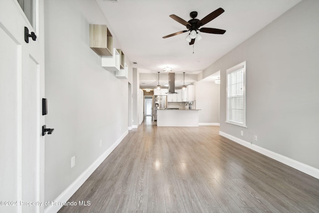 unfurnished living room featuring hardwood / wood-style floors and ceiling fan