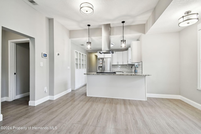 kitchen featuring stainless steel refrigerator with ice dispenser, tasteful backsplash, decorative light fixtures, light hardwood / wood-style flooring, and white cabinets