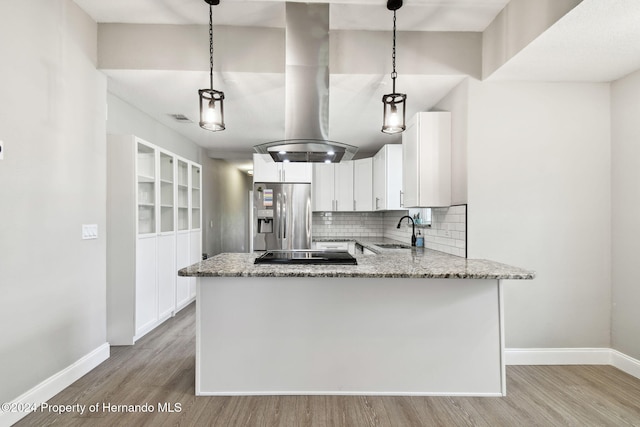 kitchen featuring white cabinets, stainless steel refrigerator with ice dispenser, pendant lighting, and sink