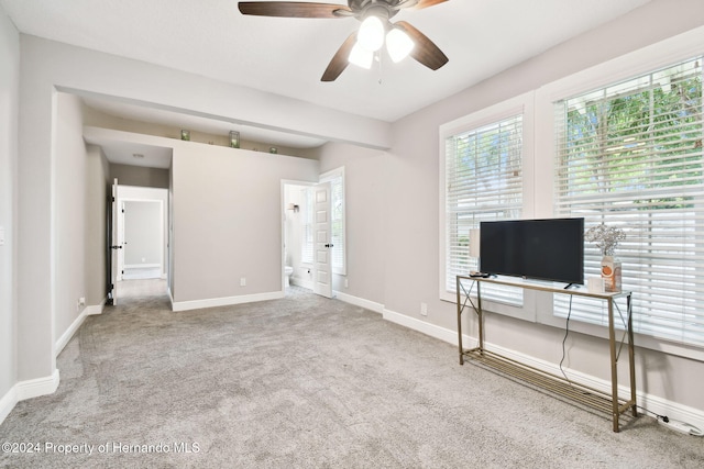 unfurnished living room featuring light carpet and ceiling fan