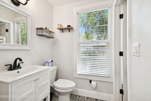 bathroom featuring vanity, toilet, and a wealth of natural light