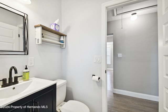 bathroom featuring vanity, hardwood / wood-style flooring, and toilet