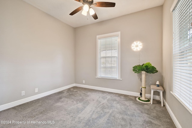 carpeted empty room featuring ceiling fan and a wealth of natural light