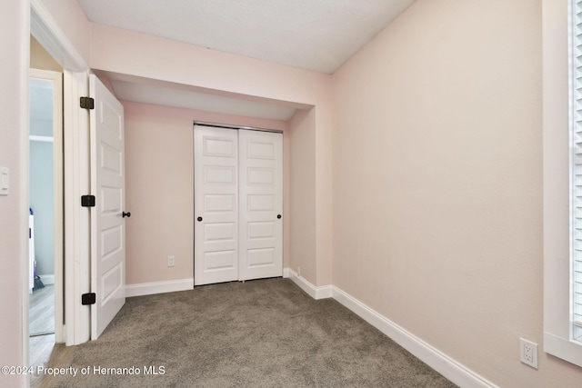 unfurnished bedroom with carpet floors and a closet