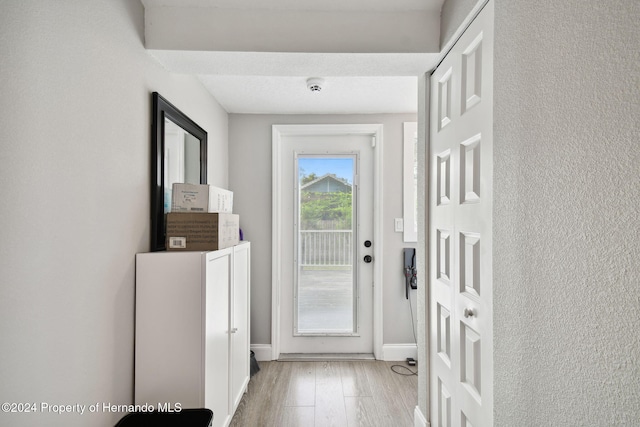 entryway with light hardwood / wood-style floors and a textured ceiling