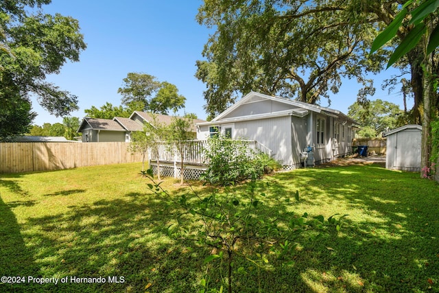 view of yard featuring a storage shed and a deck