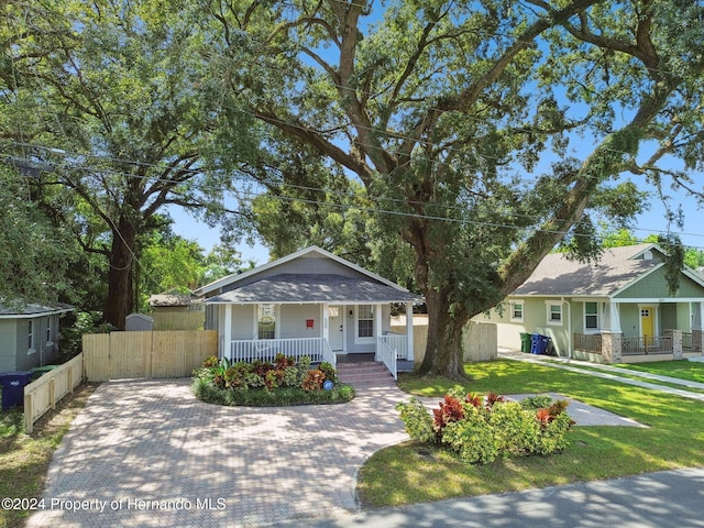 bungalow-style home with a front lawn and a porch