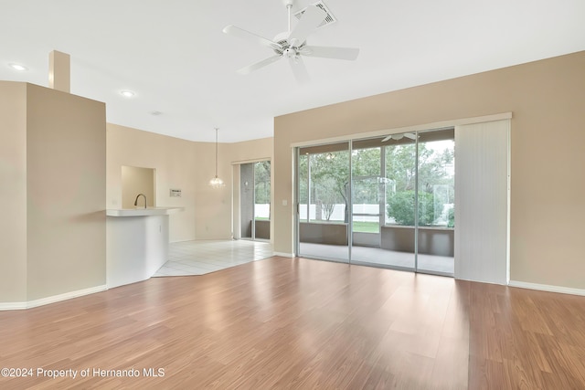 unfurnished living room with light hardwood / wood-style flooring and ceiling fan