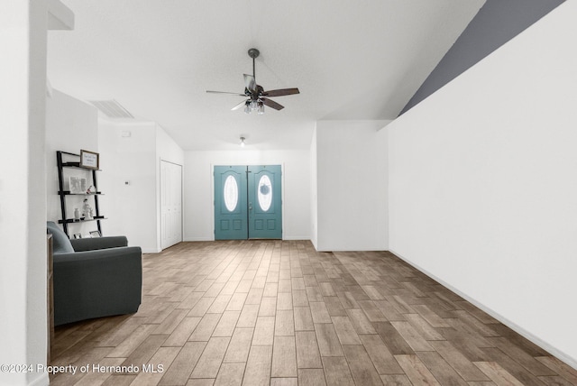 foyer entrance with ceiling fan, light hardwood / wood-style flooring, and lofted ceiling