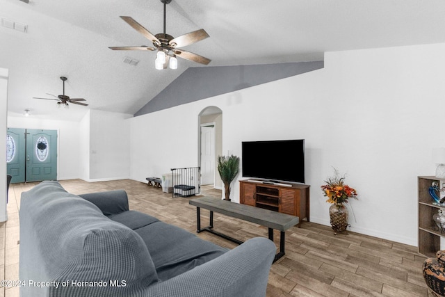 living room with light hardwood / wood-style floors, ceiling fan, and vaulted ceiling