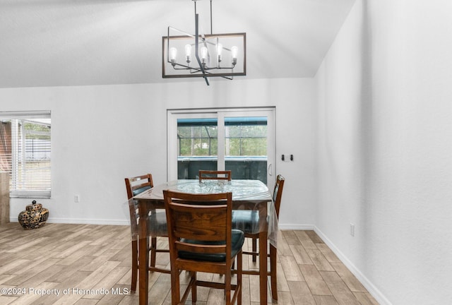 dining room featuring an inviting chandelier, a healthy amount of sunlight, light wood-type flooring, and lofted ceiling