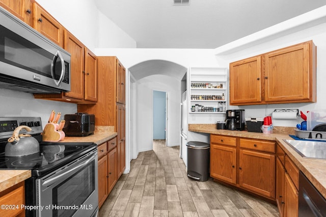 kitchen with stainless steel appliances, sink, and light wood-type flooring