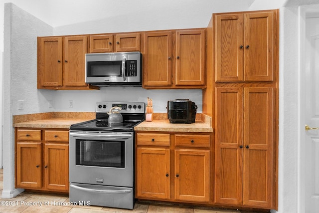 kitchen with appliances with stainless steel finishes and light tile patterned floors