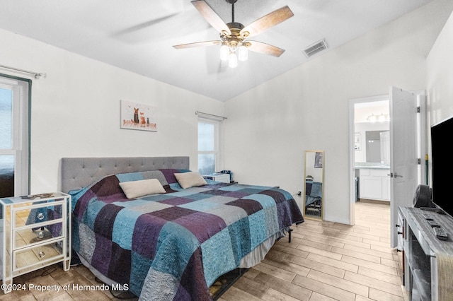 bedroom featuring hardwood / wood-style floors, ceiling fan, vaulted ceiling, and connected bathroom