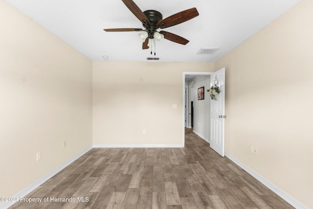 empty room with ceiling fan and light hardwood / wood-style flooring