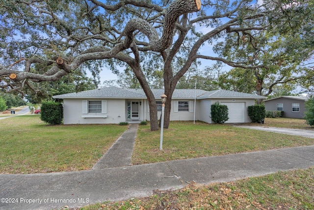 ranch-style home featuring a garage and a front lawn