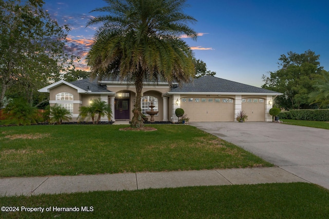 view of front of property featuring a lawn and a garage