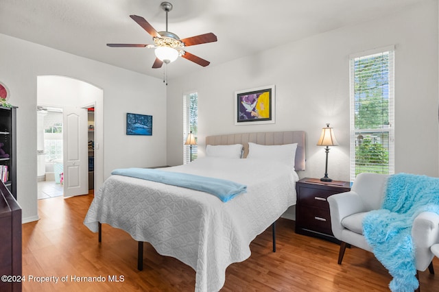 bedroom featuring hardwood / wood-style floors, ensuite bath, and ceiling fan