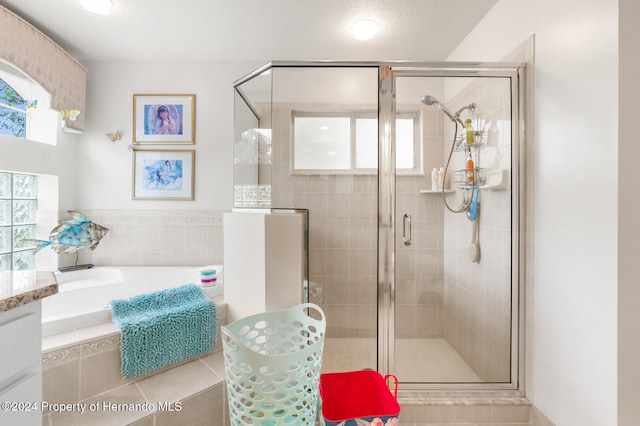 bathroom featuring tile patterned flooring, vanity, and shower with separate bathtub