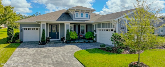 view of front facade featuring a garage, a porch, and a front lawn