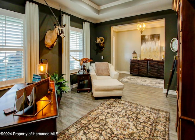 sitting room with light hardwood / wood-style floors and crown molding