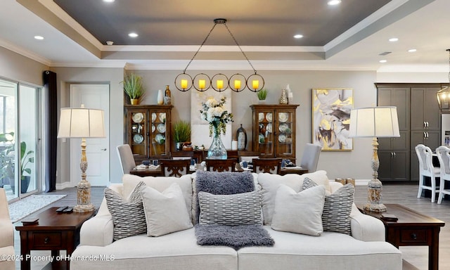 living room featuring hardwood / wood-style floors, a raised ceiling, and ornamental molding