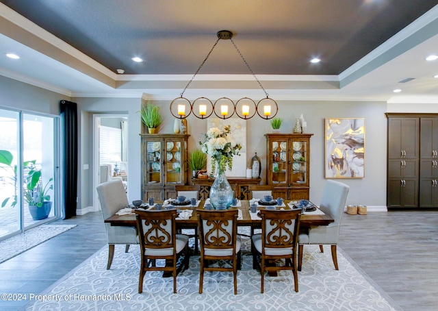 dining room featuring hardwood / wood-style flooring, crown molding, and a tray ceiling