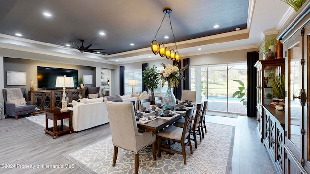 dining space with ceiling fan, ornamental molding, and a tray ceiling