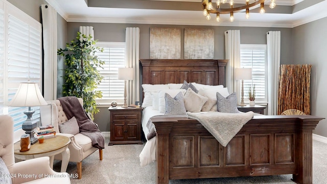 carpeted bedroom featuring ornamental molding, a chandelier, and a tray ceiling