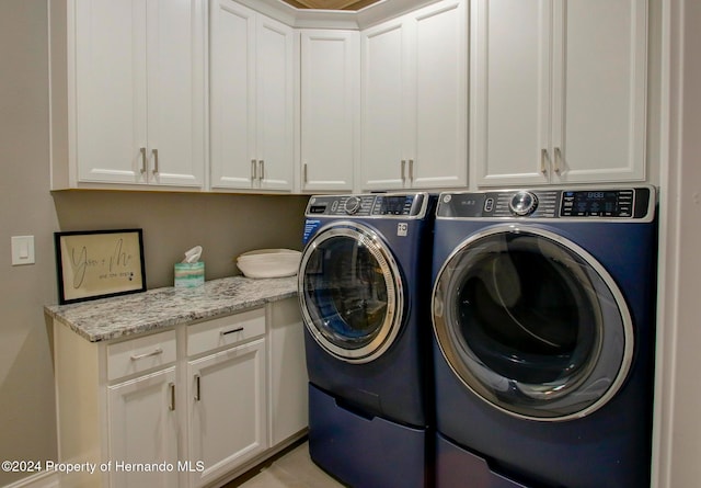 laundry area with washer and clothes dryer and cabinets