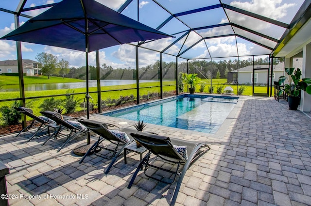 view of swimming pool with glass enclosure, a patio area, a water view, and a yard