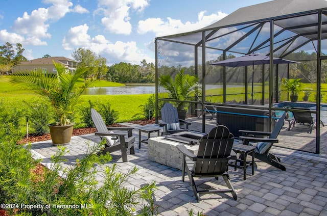 view of patio / terrace with a lanai, a water view, and a fire pit