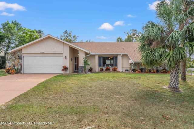 ranch-style home featuring a garage and a front lawn