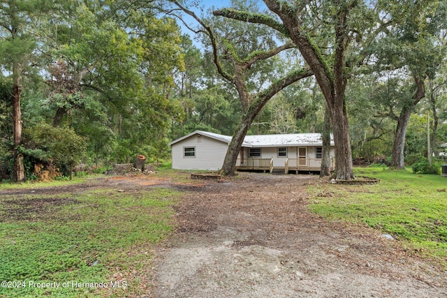 view of front facade with a front yard and a deck