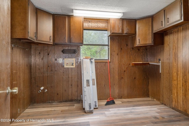 laundry room with wood walls and light hardwood / wood-style floors