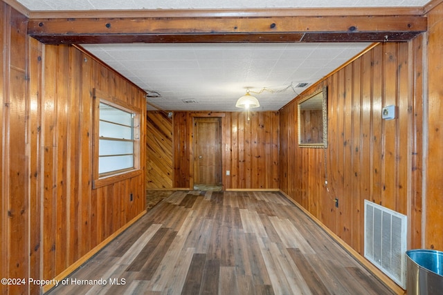 spare room featuring wood walls and hardwood / wood-style flooring