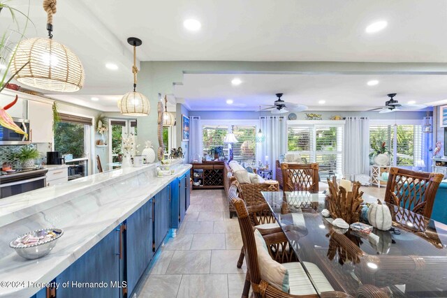 kitchen featuring light stone countertops, a healthy amount of sunlight, and decorative light fixtures