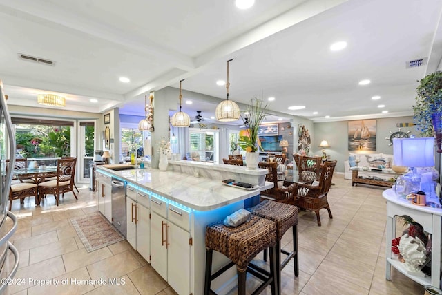 kitchen with hanging light fixtures, a kitchen breakfast bar, a healthy amount of sunlight, and a kitchen island