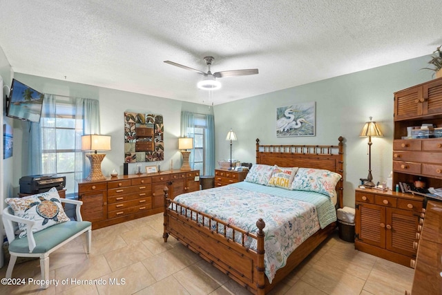 tiled bedroom with a textured ceiling and ceiling fan