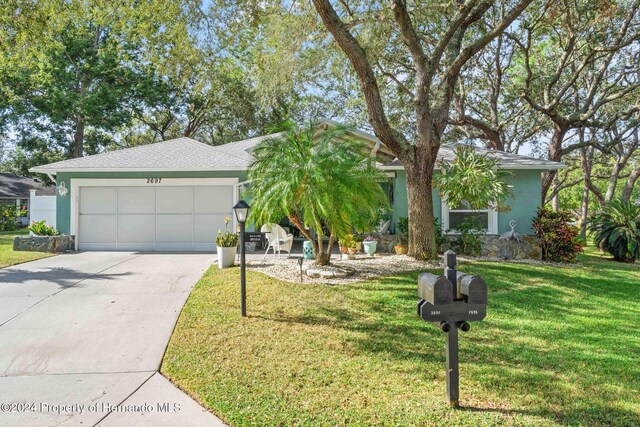 ranch-style home featuring a garage and a front lawn